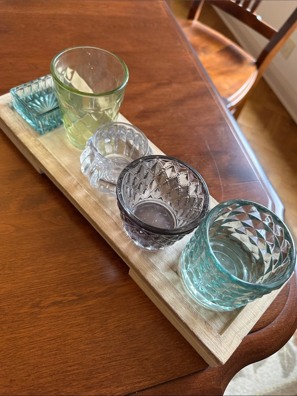 Colorful Glass Votive Set - Blue, Green, Smoke, Clear on a wooden tray.